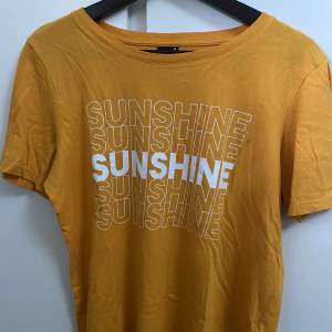 En gul T-shirt med texten Sunshine. 