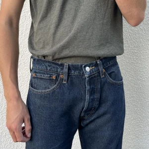 Levi’s 501 - Supersnygga mörkblå Levi’s 501 jeans i mycket gott skick! Midjemått 32, innerbenslängd 32. Modellen är man, men denna tidlösa byxa passar såklart även supersnyggt på tjejer! Skriv till mig vid frågor eller om du vill se fler bilder!🫶🏻