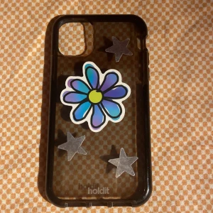 iPhone 11 skal - Superfint skal som är svart/genomskinligt från holdit. Det har klistermärken på som man kan ta bort. Och det finns några defekter (se bild 2 & 3.) Det finns repor som knappt syns. Och sen syns det lite att det har suttit en korthållare på också. 