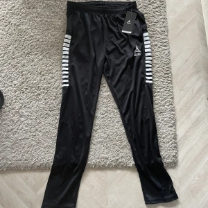 Select Träningsbyxor Slim fit - Svarta Slim-fit träningsbyxor från Select, lappen sitter fortfarande kvar. Aldrig använda. Perfekt skick. Storlek M, sitter lite tight på mig som är 181 cm lång och väger 80 kg (beror också på att de ska vara slim). Föreslå gärna pris!
