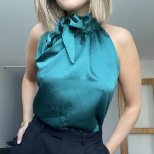 Blus - Grön blus/topp som man knyter i halsen.