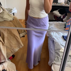 Lila långkjol - Jättefin långkjol i lent, glansigt material. Har bara använt en gång och säljer pga att jag inte har kläder att matcha med. Annars jättefin från Gina. 