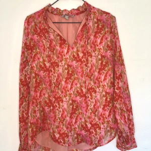 Blus H&M blommig  - Blommig blus i rött och rosa. Storlek XS-S, material polyester.  I princip  oanvänd. 