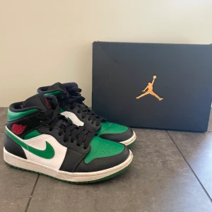 Nike Jordan 1 Pine Green - Nike Jordan 1 mid skor i färgen pine green! Köptes nya på Goat för 1600kr och är sparsamt använda av mig. Den ena skon är endast lite creasad och sulorna är lite smutsiga, annars ser de nya ut! Låda medföljer och äkthetsbevis finns!