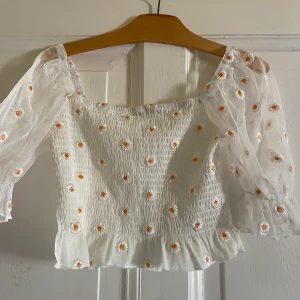 Blommig topp - Blommig topp med puffärm.