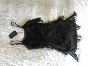 Fransklänning storlek M  - Kort svartklänning med fransar! Helt ny och så fin