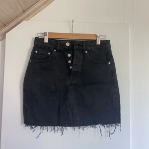 Jeanskjol - Superfin jeanskjol från Gina Tricot som tyvärr inte passar mig. Storlek 34, tvättad svart med knappar som stängning☀️fint skick! Skickar fler bilder om så önskas. 
