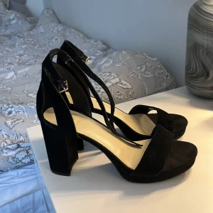 Svarta klackar - Svarta klackar med mockaimitation och öppen tå, köpta på Dinsko i vintras för 349 kr. Endast använda en gång. Klacken är ca 9 cm hög. Köparen står för frakten🤗