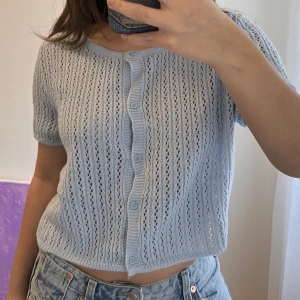 Blå stickad kofta kortärm - Stickad kofta med korta ärmar från h&m. Storlek L då jag ville ha den lite längre och lösare passform. Aldrig använd. För referens: jag är 160cm lång och har storlek XS/S i tröjor, toppar etc