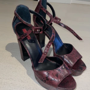 Klackskor - Fina purpurröda klackskor med 12 cm klack. De har ett ormskinnsmönster. 