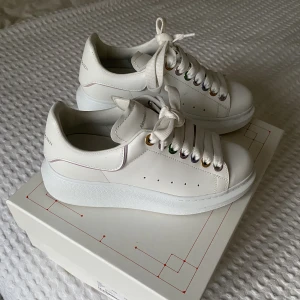 Alexander McQueen sneakers - Säljer mina Alexander McQueen sneakers i limited edition färgen white/multi då ringarna runt snörena går i olika färger och även rämmen runt McQueen märket baktill. Använda max 2 gånger och är som nya! Köpta för 5000 kr. Kvitto och box kommer med såklart💕