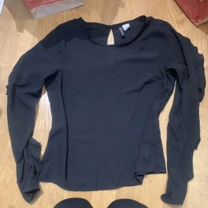 Topp - En fin svart topp som säljs för att den har blivit förliten. 