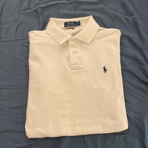 Vit Ralph lauren polo - En vit Ralph lauren polo i utmärkt skick och har inga hål eller andra defekter. Tröjan är i storlek medium.  Hör av dig för fler bilder eller frågor.