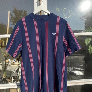 Adidas blå/lila randig T-shirt - Hej, säljer en T-shirt från Adidas i Blå/lila färg. Utmärkt skick, sparsamt använd. Storlek Large och True To Size. Nypris 500 kr. Bekvämt material och passar i de flesta lägen. Pris kan diskuteras. Hör av dig vid frågor. 