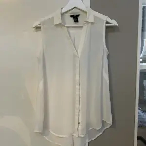 vit ärmlös blus från hm, perfekt att ha under tex stickade tröjor eller collagetröjor.