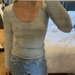 Långärmad tröja - Figursydd ljusgrå långärmad tröja från Tommy Hilfiger, köpt från Zalando.  Liten logga på bröstet med röda och blå sömmar.   Pris kan diskuteras,  Köparen står för frakt <3