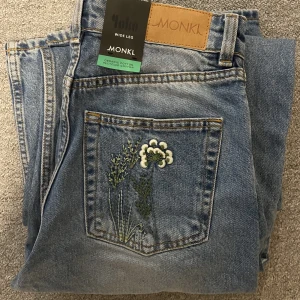 Jeans med blommor - Jättegulliga jeans från monki med blom broderier. De är vida och höga i midjan. Helt oanvända och har lapp kvar, nypris 500kr 💕