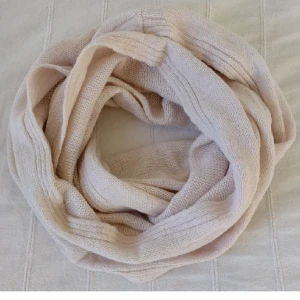 Oanvänd ljusrosa/beige stickad halsduk/tubhalsduk - Oanvänd stickad tubhalsduk i en jättefin ljus beigerosa och melerad färg. Ca 150 cm lång och 58 cm bred. Relativt tunn. 50% akryl 35% polyamid och 15% ull. På den första bilden är halsduken snurrad två gånger.