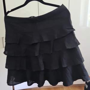 En oanvänd svart volang kjol