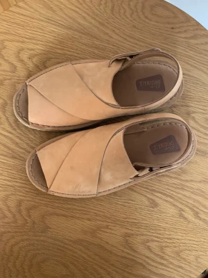 Sandaler Clarks originals  - Jätte fina clarks original i läder. Med hög sula och spännen. Använda men fortfarande fin kvalitet. 
