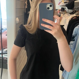 Tshirt med volang detalj  - Säljer denna svarta T-shirten från zara. Superfina volang detaljer på axlarna😊