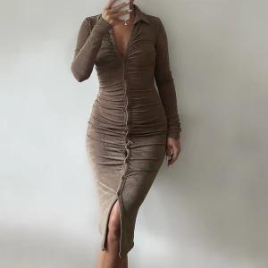 Knälång klänning - Säljer denna vackra midi dress, i en mörk beige skimmrig färg, sitter prefekt på och formar kroppen jätte fint🩷