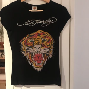 Ed Hardy t-shirt  - Svart ed Hardy t-shirt i storlek M men är mer xs-s. Väldigt strechig o inga defekter elr fläckar, säljer då den it passar min stil längre 