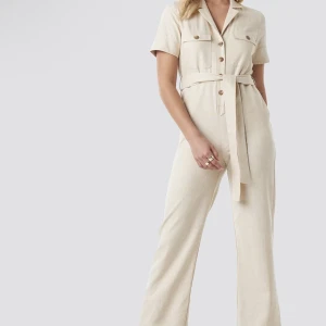 Jumpsuit - Denna beiga jumpsuit/byxdress från NA-KD säljs💕💕. Den är helt slutsåld på deras hemsida/app. Byxdressen är helt oanvänd och lappen sitter kvar på plagget.  Ordinariepris: 699kr Säljs för: 450kr Pris kan diskuteras🥰
