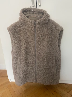 Teddyväst från Arket - Såå fin oversize teddyväst från Arket med luva. Den går strax över axlarna så fin med en stickad under! Säljer för jag har flera liknande!