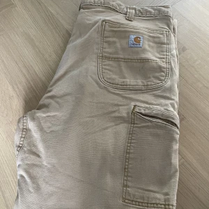 Carhartt byxor - Carhartt byxor i stl 38W 32L i bra skick med vintage stil i mörk beige. Sitter väldigt bra med flera typer av skor. Skicka meddelande för fler bilder.