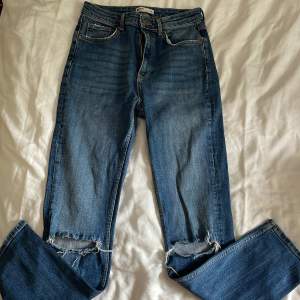 Jeans med slitningar på knäna från Gina tricot i stl 38.