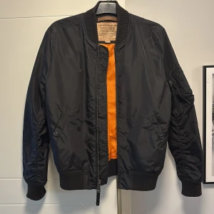 Svart bomberjacka från Alpha industries  - Skön och vindtät bomberjacka i gott skicka. Två innerfickor. Strl M