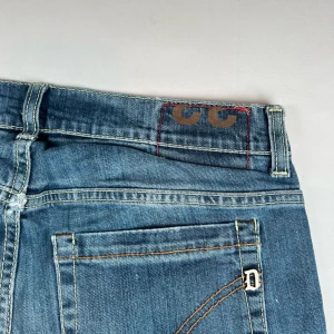 Blå jeans från dondup - Snygga blå jeans från dondup med klassisk femficksdesign och coola detaljer på bakfickorna. De har en normal passform och är perfekta för en avslappnad stil. Midjan är midwaist och materialet är slitstarkt jeans.