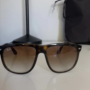 Ray-Ban boyfriend - Snygga solglasögon från Ray-Ban med en klassisk brun sköldpaddsmönstrad båge. De har en stilren design med Ray-Ban-loggan på sidan och tonade glas. Perfekta för soliga dagar!