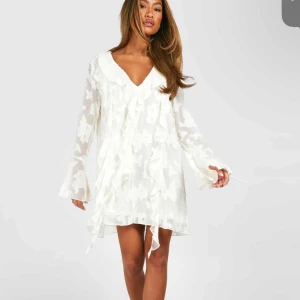 Vit klänning med volanger - Säljer min vita klänning med volanger och v-ringning. Använd en gång så den är som ny. Jättefin till sommaren🥰