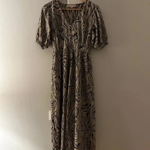 Mönstrad klänning från Pernilla Wahlgren - Snygg klänning från Pernilla Wahlgren i ett coolt zebramönster. Klänningen har korta ärmar och en bekväm passform. Tillverkad i 100% polyester, perfekt för en stilfull look.