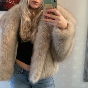 Beige pälsjacka från Zara - Säljer en lyxig beige pälsjacka från Zara. Jackan har en fluffig och mjuk textur med en elegant krage. Perfekt för att hålla sig varm och stilren under kyliga dagar.