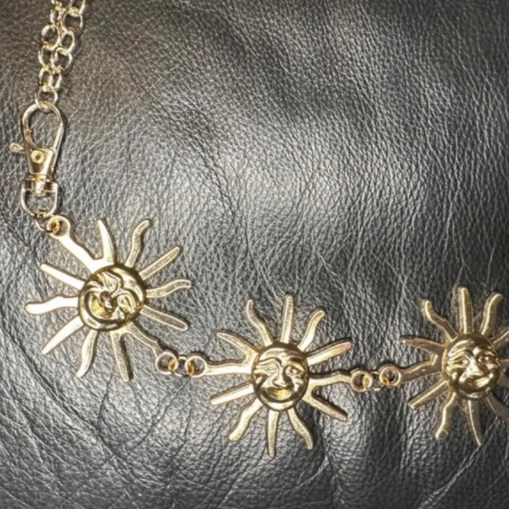 Fånga blickar med detta fantastiska kedjebälte i gyllene metall med strålande solberlocker! Perfekt accessoar för dig som gillar boho, festivalstil eller en somrig, alternativ look. Bältet är justerbart, flexibelt och bekvämt att bära. Stängs enkelt med hake och avslutas med en liten dekorativ solberlock. Supersnyggt till både klänning, kjol eller över en oversize skjorta. • Längd: ca 110 cm • Solberlocker: ca 5 cm höga • Material: Metall Prutar inte men jag erbjuder bundlerabatt!. Asusteet.