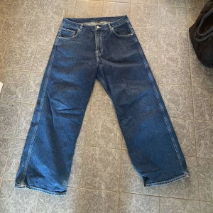 Baggy blåa jeans - Säljer blåa jeans med baggy passform. Byxorna är i bra skick med lite slitage vid ändarna.