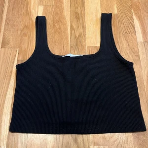 Svart ribbad linnetopp - Säljer en stilren svart ribbad linnetopp i storlek XL. Toppen har breda axelband och en rundad halsrigning. Perfekt för att matcha med olika outfits. 🖤