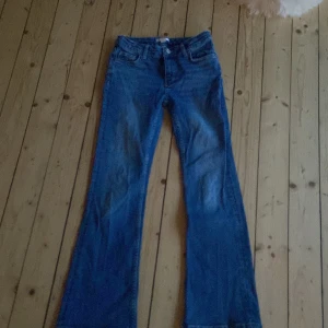 Blå jeans från Gina Tricot - Snygga blå jeans från Gina Tricot med bootcut-stil. Resorbanden på insidan har rensat upp lite. Använt ungefär 4 gånger. Säljer pga att jag väckt ut de💕