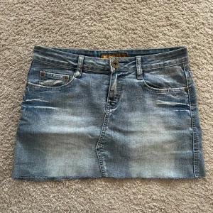 Lågmidjad jeanskjol  - Superfin Lågmidjad jeanskjol. Mått finns på bild 2 & 3. Hör av dig om du har frågor eller funderingar🤗 Storlek 26. Passar mig som brukar ha S