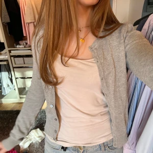 Grå kofta - Säljer en stilren grå kofta med knappar framtill.  passar till många olika outfits. Koftan har långa ärmar och en klassisk design.