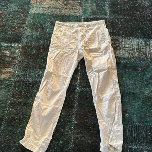 Benvita byxor från East West - Säljer ett par tunna benvita byxor från East West 100% bomull perfekta till sommaren. De har en klassisk design med normal passform och midwaist. Perfekta för en stilren look.