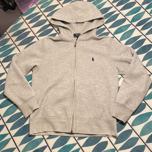 Ralph Lauren Zip Hoodie - Säljer min Ralph Lauren Zip Hoodie! STORLEK: M (10-12) (BARNSTORLEK) 👍(säljer då den är för liten för mig). Passar dig som är ungefär 145-155 men även lite längre 🤩INGA defekter (finns bild BAK och FRAMSIDA) Perfekt skick och tecken på användning syns bara vid riktigt riktigt noggran inspektion 🤑PRIS KAN DISKUTERAS VID SNABB AFFÄR 🐺