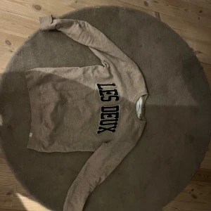 Beige tröja från Les Deux - Säljer en beige tröja från Les Deux med text på framsidan. Tröjan har långa ärmar och en rund halsringning. Storlek M, priset är ej hugget i sten
