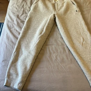 Ralph lauren mjukis byxor  - Säljer ett par bekväma grå mjukisbyxor från Polo Ralph Lauren. Byxorna har en elastisk midja med snörning och sidofickor. Perfekta för en avslappnad stil.(Det är XL i junior storlekar men passar S i herr) om ni har några frågor är det att bara att skriva till mig -MVH Marko