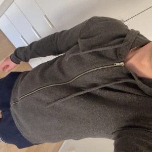 Grå snygg hoodie från Jack & Jones - Säljer en stilren grå hoodie från Jack & Jones. Den har en dragkedja framtill och långa ärmar. 