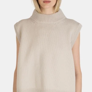 Nathalie Schuterman Gilda Cashmere Top Earl Grey S-M - Ärmlös stickad tröja med hög krage. Super mjuk, 100% cashmere. Den har en ribbstickad detalj nedtill och upptill.  Köpt på Nathalie Schuterman butiken på Birger Jarlsgatan för 9895kr. Endast testad! Inga defekter!