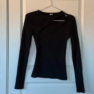 Svart långärmad topp från NLY Trend - Snygg svart långärmad topp från NLY Trend med asymmetrisk design vid halsen. 